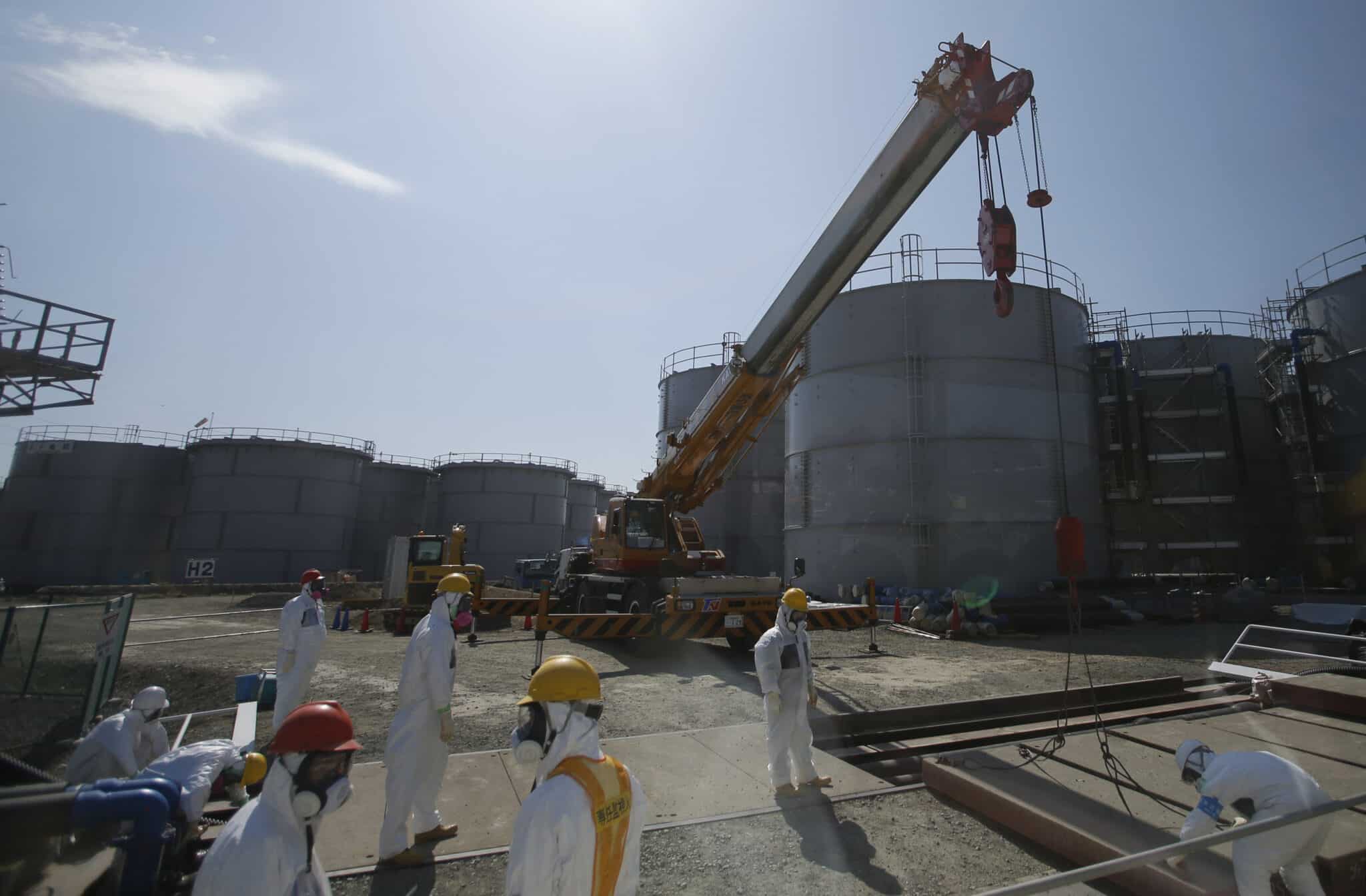 Des travailleurs prêts d'un réservoir d'eau de la centrale de Fukushima au Japon © AFP PHOTO / POOL / Issei KATO 