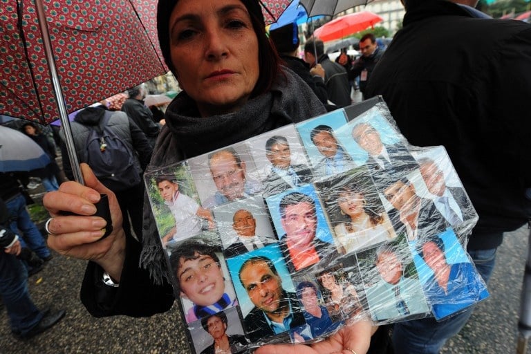 Naples, Italie: une femme tiens une affiche avec les photos de ses proches et amis décédés d'un cancer lors d'une manifestation ce week-end à Naples. © AFP PHOTO/ MARIO LAPORTA