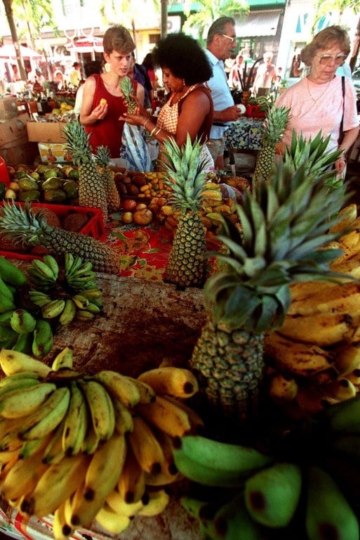 FRANCE, POINTE-A-PITRE : marchande de fruits installée sur le marché de Pointe-à-Pitre en Guadeloupe. L'UICN et le MNHN viennent de publier le premier volet de la Liste rouge des espèces de la flore menacée en Guadeloupe et Martinique. © AFP