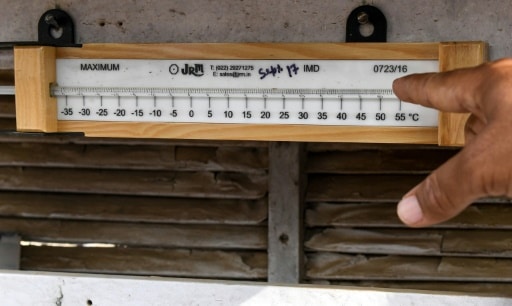 Un Indien pointe du doigt la température indiquée par un thermomètre à Churu en Inde © AFP Money SHARMA