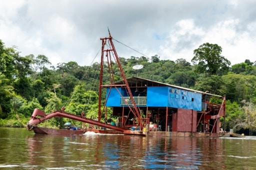 Une barge utilisée pour l'orpaillage sur le fleuve Maroni, près du village de Twenké, le 12 juin 2019 dans le sud-ouest de la Guyane © AFP jody amiet
