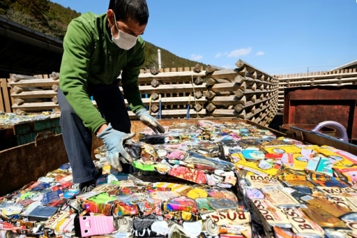 Un employé de la décharge de Kamikatsu empile des cannettes compactées, le 14 mars 2019 au Japon © AFP Kazuhiro NOGI