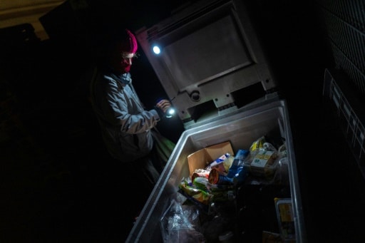 Un "cambrioleur de poubelles" inspecte celle d'un supermarché pour lutter contre le gaspillage alimentaire, le 17 mai 2019 à Berlin © AFP John MACDOUGALL