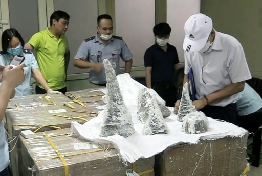 Des agents des douanes de l'aéroport international de Noi Bai sortent des morceaux de cornes de rhinocéros de leur emballage à Hanoi, le 25 juillet 2019 © Vietnam News Agency/AFP Vietnam News Agency