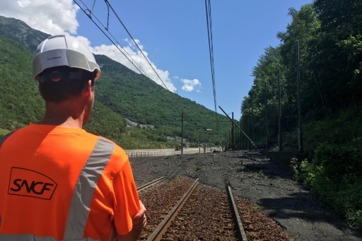Un employé de la SNCF inspecte une section de voie ferrée recouverte par une coulée de boue due aux orages, le 3 juillet 2019 à Saint-Michel-de-Maurienne (Savoie), dans les Alpes françaises. © AFP Odile DUPERRY