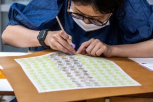 employée réalise le motif d'un textile à Naha, dans la préfecture d'Okinawa au Japon