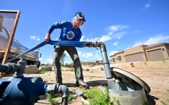 John Hornewer livre de l'eau à des habitations avec son camion-citerne à Rio Verde Foothills