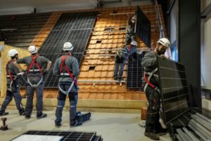 Des employés s'entraînent à la pose de panneaux solaires sur des toitures