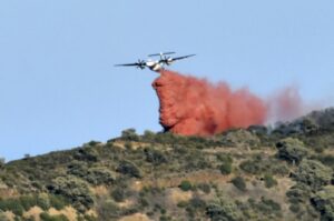 Un avion largue un produit retardant sur un feu