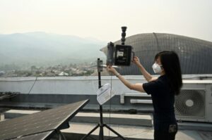 Une scientifique verifie la qualité de l'air, sur le toit de l'Institut national de recherche astronomique 