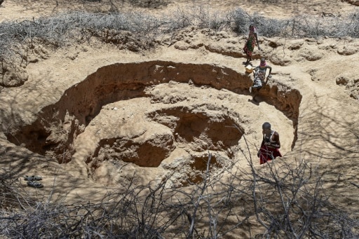 Des femmes et des enfants cherchent de l'eau dans un puits creusé