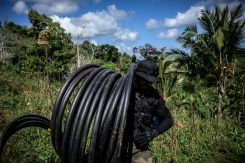 Un homme transporte un tuyau d'eau 